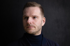 Portret van een zelfverzekerde man die schuin wegkijkt, met een stoere uitstraling. Een krachtige en zelfbewuste pose, ideaal voor professionele portretten en persoonlijke branding.